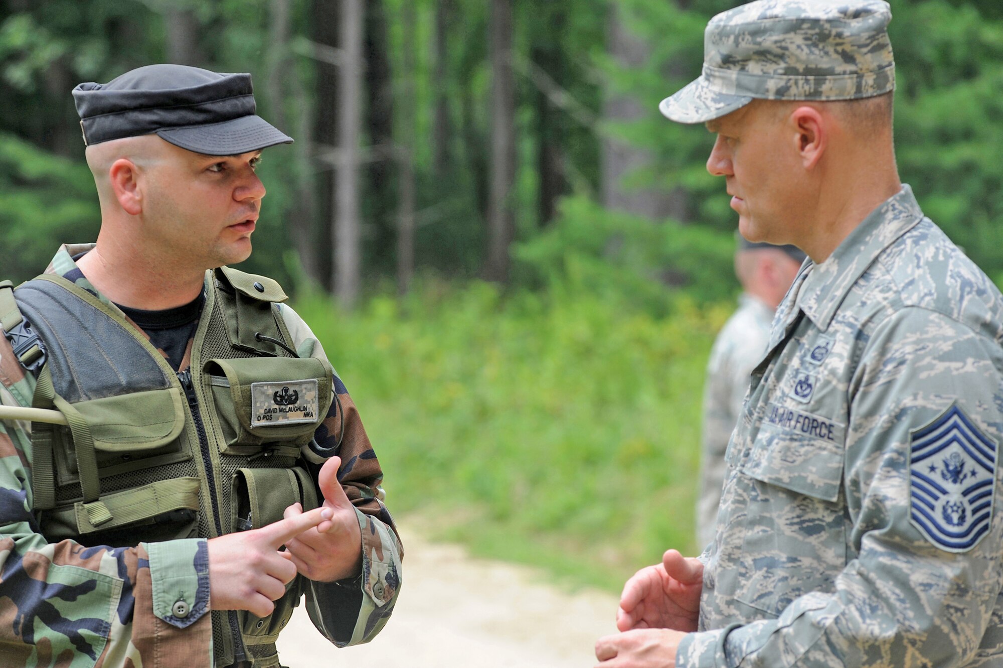 Staff Sgt. David McLaughlin briefs Chief Master Sgt. of the Air Force James Roy on how his unit contributes to the U.S. Air Force Expeditionary Center's courses for deploying Airmen during a visit to a Fort Dix range July 29 on Joint Base McGuire-Dix-Lakehurst, N.J. Chief Roy visited the U.S. Air Force Expeditionary Center on Fort Dix and McGuire Air Force Base to learn more about expeditionary training and operations in both areas. Sergeant McLaughlin is assigned to the U.S. Air Force Expeditionary Center's 421st Combat Training Squadron Explosive ordnance disposal section. (U.S. Air Force Photo/Staff Sgt. Nathan G. Bevier) 