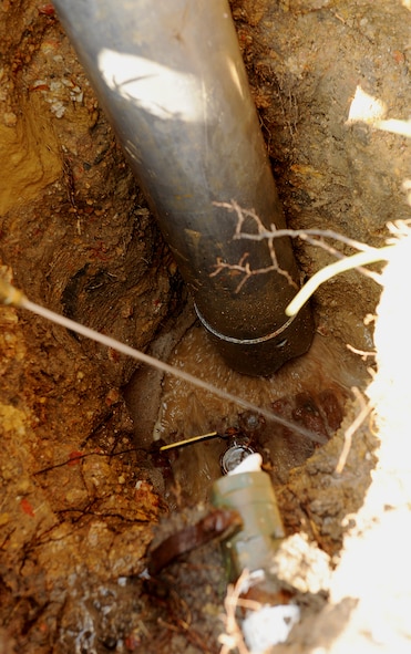 MOODY AIR FORCE BASE, Ga. -- Members from the 23rd Civil Engineer Squadron use a Vac-Con pipe to remove water from a hole after a main water line leak here Aug. 11. The Vac-Con pipe is attached to a truck and used to remove water from areas during flood situations. (U.S. Air Force photo by Airman 1st Class Joshua Green)