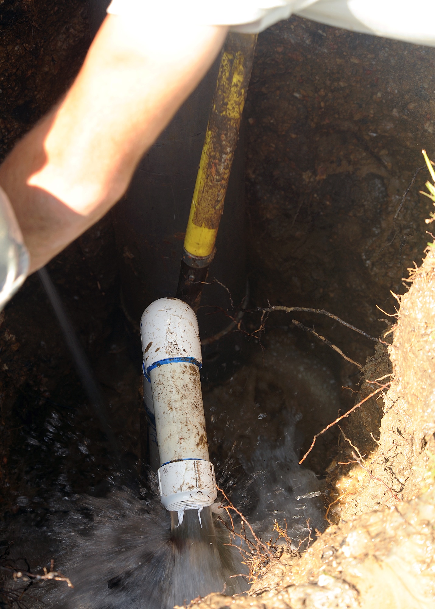 MOODY AIR FORCE BASE, Ga. -- Airmen from the 23rd Civil Engineer Squadron repair a main water line leak here Aug. 11. The Airmen accessed the damaged pipe by digging a hole and suctioning out excess water to get to the source of the leak. (U.S. Air Force photo by Airman 1st Class Joshua Green)