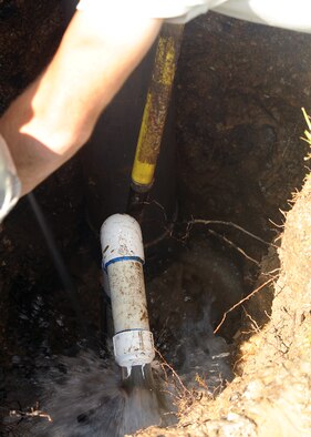 MOODY AIR FORCE BASE, Ga. -- Airmen from the 23rd Civil Engineer Squadron repair a main water line leak here Aug. 11. The Airmen accessed the damaged pipe by digging a hole and suctioning out excess water to get to the source of the leak. (U.S. Air Force photo by Airman 1st Class Joshua Green)
