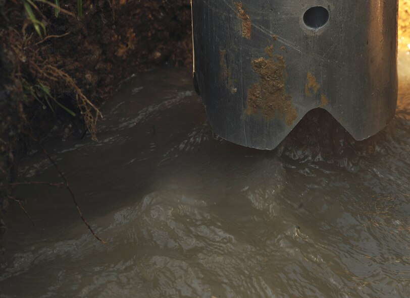 MOODY AIR FORCE BASE, Ga. -- A Vac-Con pipe removes water from a hole caused by a main water line leak here Aug. 11. The Vac-Con equipment is attached to a truck, which suctions out water and stores it in the vehicle’s tank. (U.S. Air Force photo by Airman 1st Class Joshua Green)