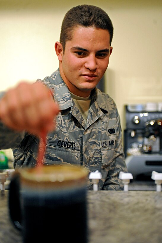 Airman 1st Class Sean Geverts, 28th Logistics Readiness Squadron material management inspector and member of the Airmen Ministry Council, stirs a cup of coffee during an open house for wing leadership at the Airmen Ministry Center here, August 11. The open house showed leadership all the activities offered for dormitory residents. (U.S. Air Force photo/Airman 1st Class Matthew Flynn) 
