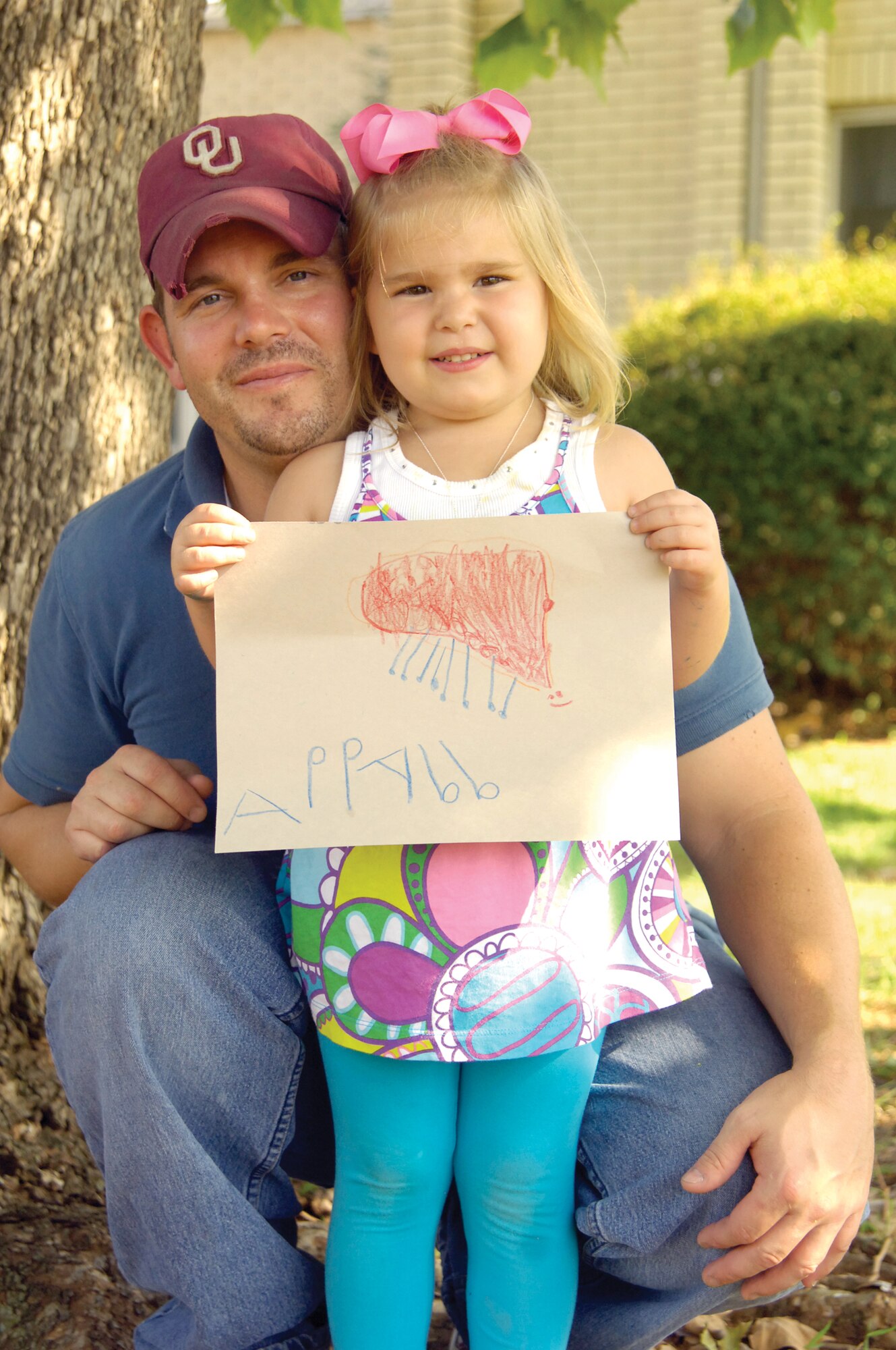 Recently, Shawn Randol picked up more than his daughter from Tinker’s Child Development Center West one day after work. In the shade of the facility’s large tree was a lone kitten that seemed injured. The 76th Commodities Maintenance Group sheet metal mechanic and his daughter, Abbie, 4, took the kitten to a veterinarian. Around $200 later, the diagnosis was that the tiny creature had suffered a concussion. Mr. Randol was attached and Socksy became a part of the family. Left, Abbie displays her drawing of the kitten that now lives with cows, chickens, horses and a dog on the family’s land in Mulhall, Okla. (Air Force photo by Margo Wright)
