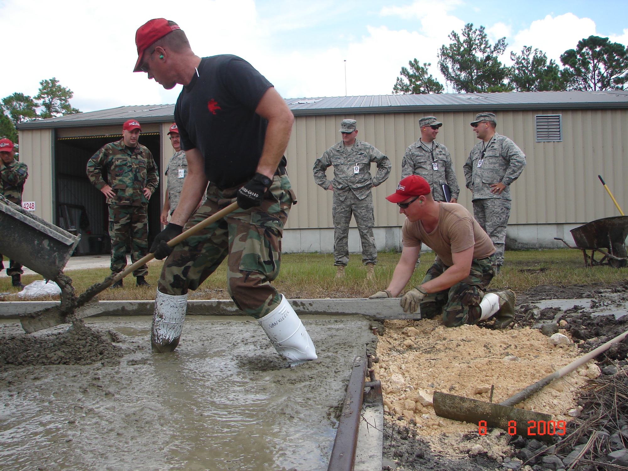 SSGT Mark Van Kleek (on rake) and SSGT Kevin Barfield (on screed) assist in a "concrete pour" at the 202nd RED HORSE compound at Camp Blanding during an August 2009 Unit Compliance Inspection, while UCI Team Chief Colonel Mark Moore and UCI Team Members MSGT Shane Rogers and Lt.Col. Erik Lagerquist evaluate the operation.  Colonel Moore stated the 202nd RED HORSE did "very, very well" in the Unit Compliance Inspection.
