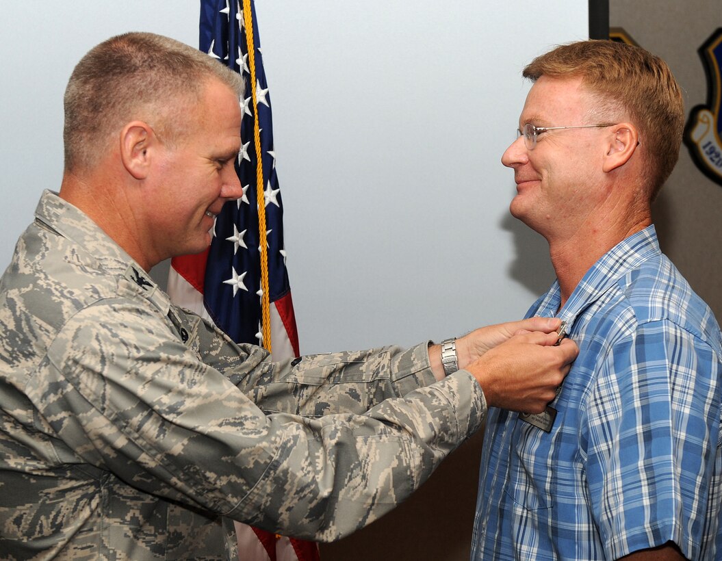 LANGLEY AIR FORCE BASE, Va. --  Col. Geroge A. Zaniewski, 1st Maintenance Group commander, pins the Secretary of Defense Civilian Global War on Terrorism Service Medal on Mr. Keith Weisser, 1st MXG engineering and technical services avionic lead, here Aug. 14.  Mr. Weisser was awarded this medal for avionic support while deployed from December 2001 to March 2002.  (U.S. Air Force photo/Senior Airman Zachary Wolf)