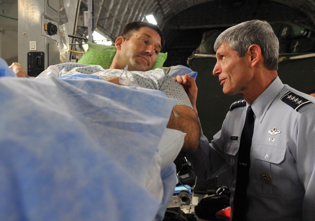 General Norton A. Schwartz, Chief of Staff of the Air Force, speaks with Tech. Sgt. Michael Williams, a returning Wounded Warrior, during an aeromedical evacuation mission on the Andrews flightline Aug. 7. The 779th Medical Group has the busiest aeromedical staging facility in the continental U.S., caring for more than 100 wounded and ill servicemembers returning to America each week. (U.S. Air Force photo/ Staff Sgt. Renae Kleckner)