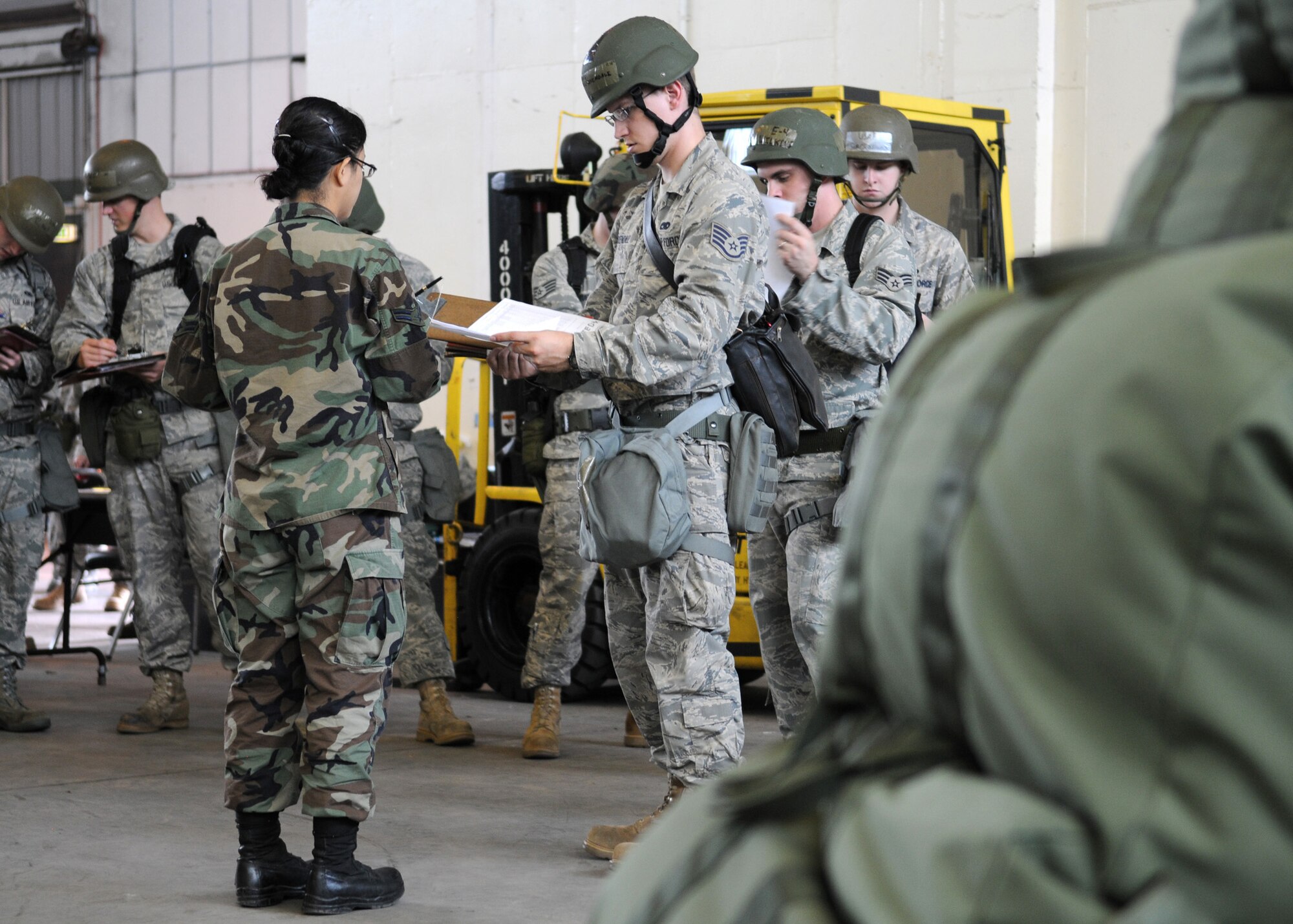 RAF MILDENHALL, England - Airmen stand in a line waiting to receive simulated chemical gear bags during initial inprocessing for Phase I of the exercise at Building 550 Aug. 13. Airmen participating in the exercise practice for the possibilities of a real world deployment. (U.S. Air Force photo by Staff Sgt. Jerry Fleshman)