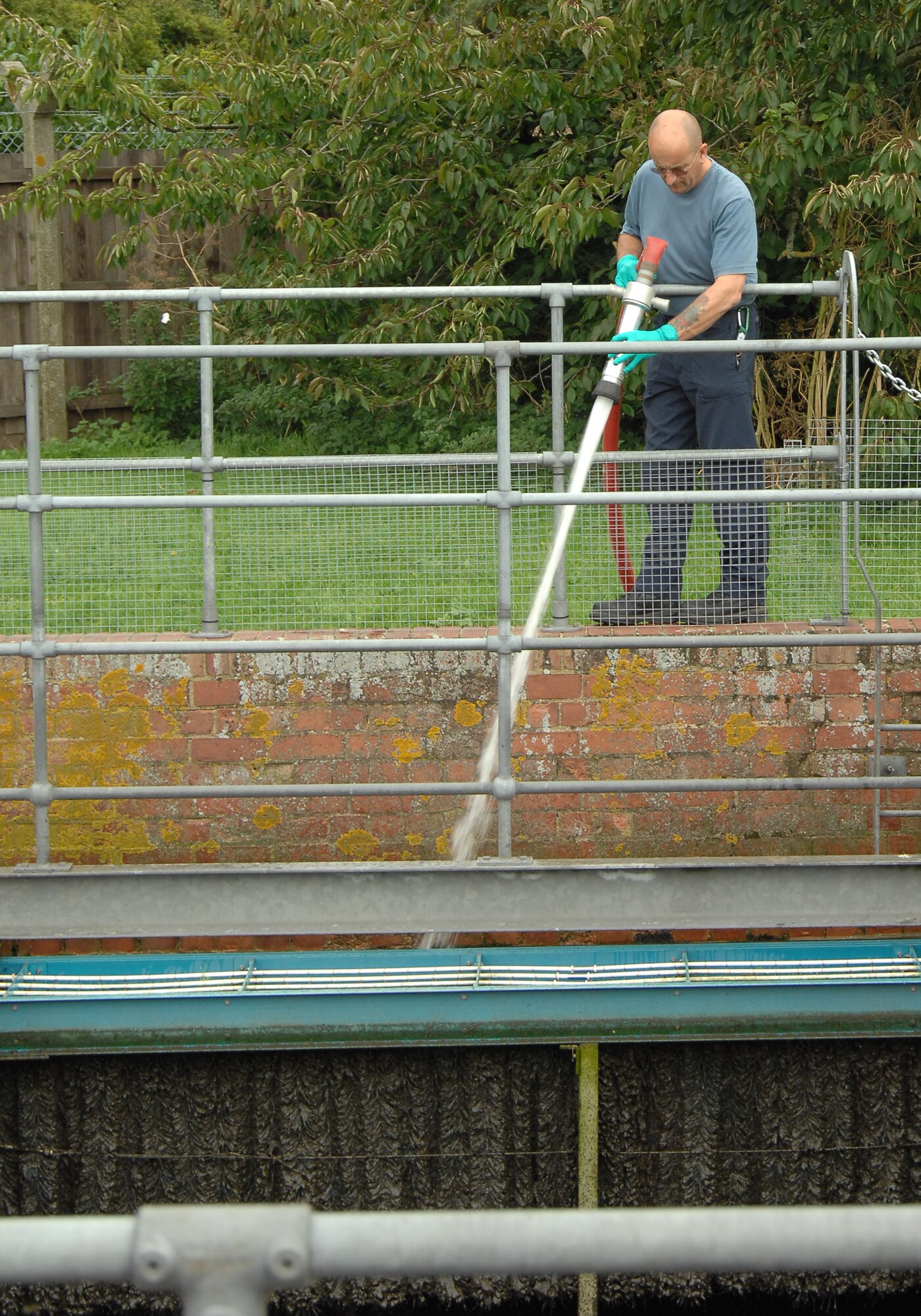 Patrick Goddard, 48th Civil Engineer Squadron Waste and Water Treatment operator, hoses down a waste tank to avoid septic shock, August 6, 2009, at RAF Lakenheath, England. This prevents scum and other unwanted fluids from being returned to the environment. The waste and water plant cleans the water by passing it through several treatment and filtration processes before reintroducing it into the environment. (U.S. Air Force photo/Cassie Coleman)