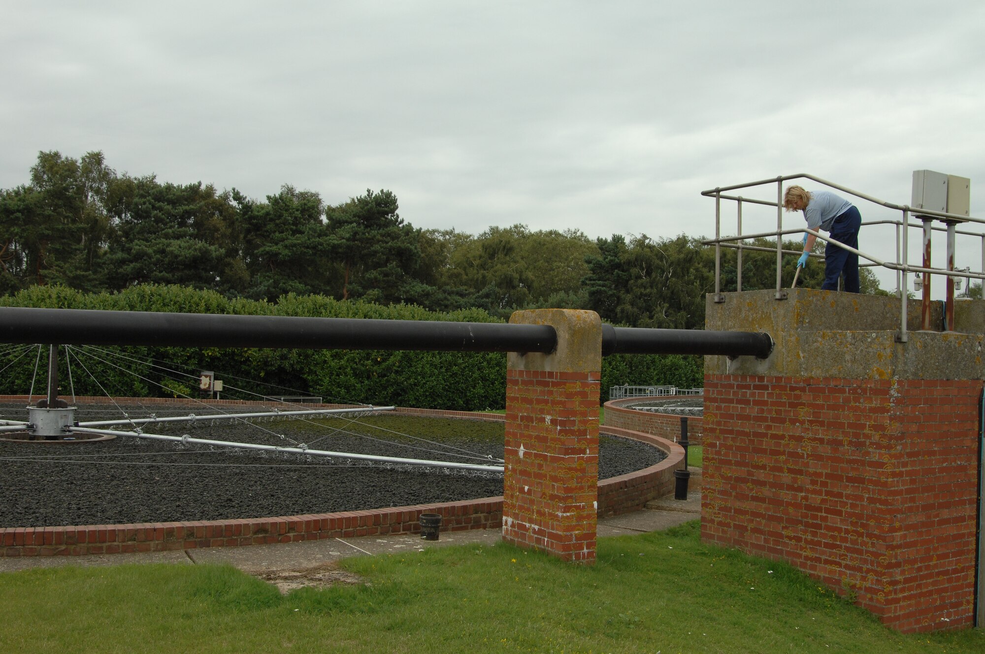 Emma Bailey-Willis, 48th Civil Engineer Squadron Waste and Water Treatment operator, sweeps scum and other debris off a walkway at the water treatment plant August 6, 2009, at RAF Lakenheath, England. Staff members at the water treatment plant are responsible for keeping the plant clean and running smooth, as well as keeping it in compliance with environmental standards. The waste and water plant cleans the water by passing it through several treatment and filtration processes before reintroducing it into the environment. (U.S. Air Force photo/Cassie Coleman) 