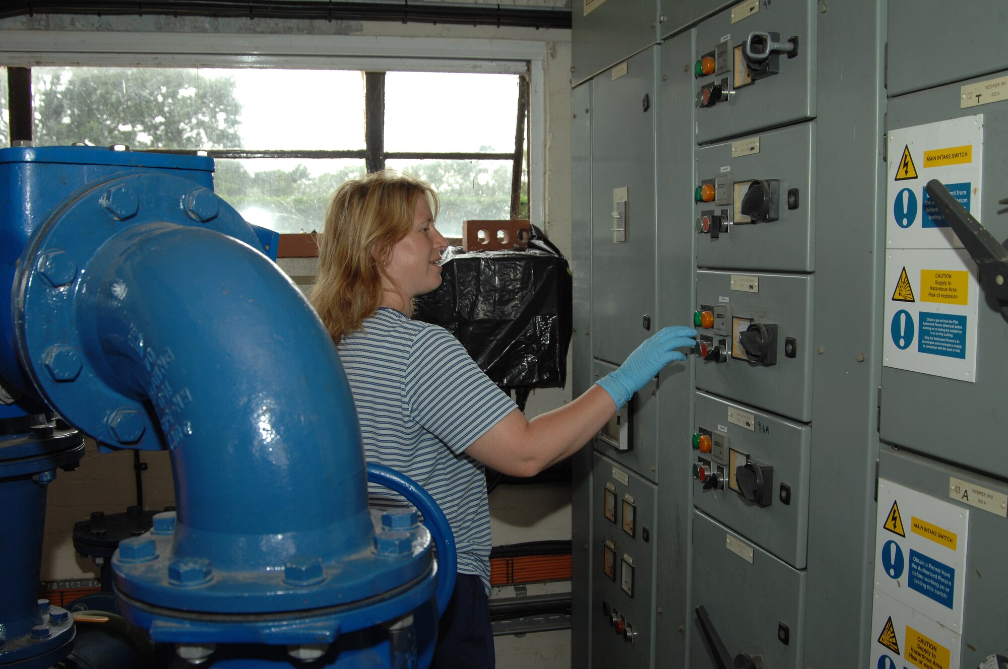 Emma Bailey-Willis, 48th Civil Engineer Squadron Waste and Water Treatment operator, flips a switch to swap the pumps in the main pump house, August 6, 2009, at RAF Lakenheath, England. The pumps are swapped to prevent one pump from running continuously and burning out. The waste and water plant cleans the water by passing it through several treatment and filtration processes before reintroducing it into the environment.  (U.S. Air Force photo/Cassie Coleman) 