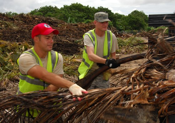 ANDERSEN AIR FORCE BASE, Guam ? Senior Airman Paul Triggs, 554th RED HORSE Squadron vehicle maintenance, and Senior Airman Matthew Hubbard, 734th AMS information controller, unload palm fronds and debris from a truck at the base landfill here August 4. The Airmen were volunteers in support of Andersen's base pride detail program. (U.S. Air Force photo by Senior Airman Shane Dunaway)