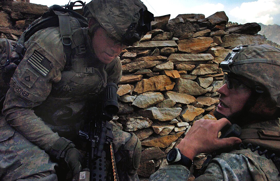 U.S. Army Sgt. Graham Mullins, left, gives an order to U.S. Army Pfc. Damian Gardner as insurgents fire on their position during an early morning gun battle in the Korengal Valley, Kunar province, Afghanistan, Aug. 13, 2009. Mullins and Gardner, are assigned to the 4th Infantry Division's Company B, 2nd Battalion, 12th Infantry Regiment, 4th Brigade Combat Team.