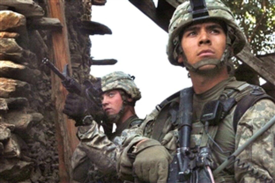 A U.S. Army soldier and U.S. Air Force airman scan the rocky hillside as fellow members return fire at insurgents during an early morning gun battle in the Korengal valley in Kunar province, Afghanistan, Aug. 13, 2009. Both servicemembers are assigned to the  4th Infantry Division's Company B, 2nd Battalion, 12th Infantry Regiment, 4th Brigade Combat Team. International Security Assistance Forces across Afghanistan have increased operations to ensure safety and security during Afghanistan’s seco