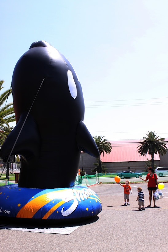 A mother calls to her sons as they stare at a towering Shamu ballon at the ITT Latitudes & Travel Expo at Camp Pendleton, Aug. 14. Camp Pendleton service members and their families received free food, gifts, activities and information from a variety of entertainment services.