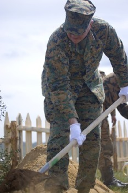 Lt. Gen. Keith J. Stalder digs a hole before planting a tree as part of a groundbreaking ceremony for the new Peacekeeping Park Aug. 15 at Five Hills Training Area, Mongolia. The president of Mongolia, Ts. Elbegdorj, and the Mongolian minister of defense, L. Bold, also participated in the event. (Official Marine Corps photo by Cpl. Daniel H. Woodall)