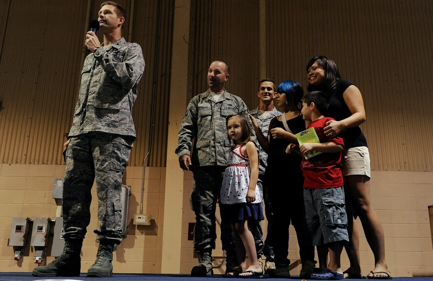 MOODY AIR FORCE BASE, Ga. – (Left) Col. Gary Henderson, 23rd Wing commander, speaks to a crowd comprised of Airmen from the 23rd Aircraft Maintenance Unit who returned from a six-month deployment, as well as their family members and friends, here Aug. 15. During the commander’s speech, (right) Tech. Sgt. Ronald Sprading, 23rd Equipment Maintenance Squadron aircraft structural maintainer and his family, are surprised with the news that he has been selected for the Stripes for Exceptional Performers promotion and will be promoted to the rank of master sergeant. (U.S. Air Force photo by Airman 1st Class Joshua Green)