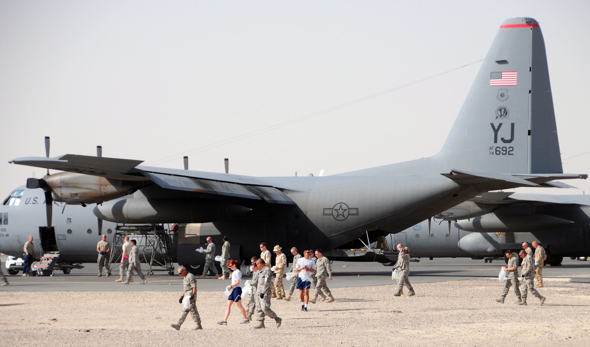 Members of the 386th Air Expeditionary Wing, Life Support Area and Australian Defence Force Support Unit Two walk the flightline in search of foreign object debris (FOD) at an undisclosed location in Southwest Asia August 15. FOD on the flightline can be ingested and severely damage aircraft engines. Prizes were awarded to the finders of four "Golden Bolts" hidden on the flightline during the FOD walk.  (U.S. Air Force photo/Tech Sgt. Tony Tolley)