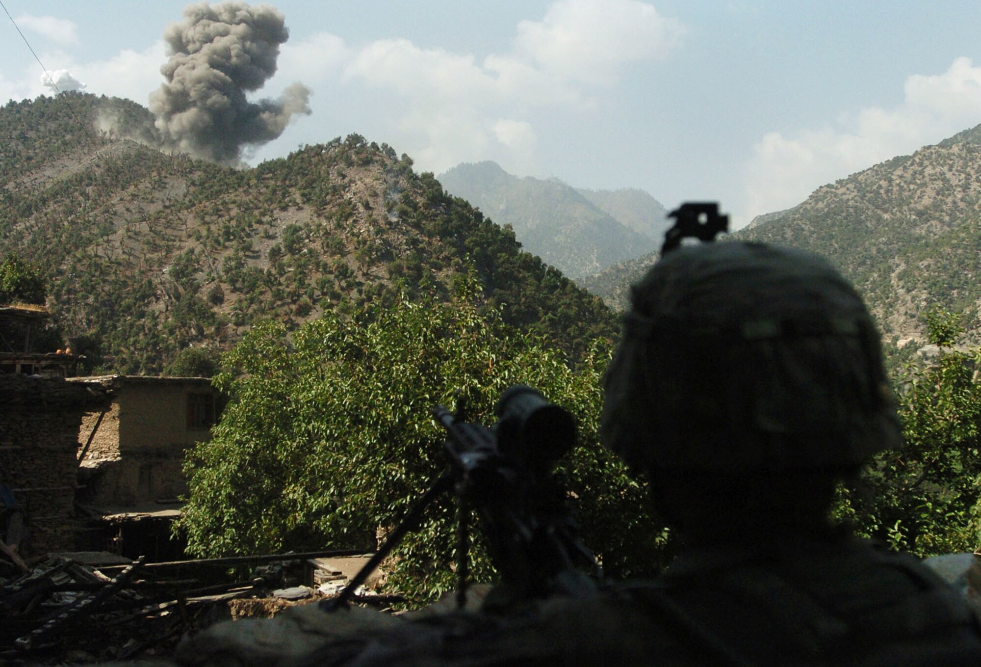 KUNAR PROVINCE, Afghanistan - A U.S. Army Soldier watches as U.S. Air Force F-15 Fighter Jets destroy insurgent positions with a bomb, after a 20 minute gun battle in Kunar province Afghanistan's Korengal Valley, Aug. 13. U.S. Service Members from Company B, 2nd Battalion, 12th Infantry Regiment, 4th Brigade Combat Team, 4th Infantry Division, routinely engage insurgents in the volatile valley. International Security Assistance Forces across Afghanistan have increased operations in recent months, in order to ensure safety and security during Afghanistan's second national election, scheduled for the end of August. (U.S. Army photo/Sgt. Matthew Moeller)