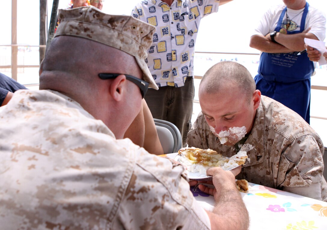 Lance Cpl. Jonathan Gray, administrative clerk, Security Battalion, Marine Corps Base Camp Pendleton, devours an apple pie during a half-a-pie eating contest for Security Battalion's Family Day at Del Mar Beach, Aug.15.