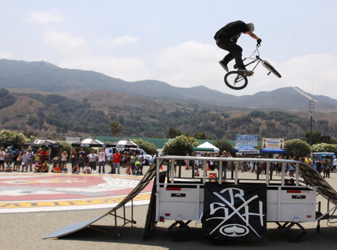 Caleb M. Norman, a bicycle motocross rider with Supporting Radical Habbits Productions, removes his feet from his bicycle in mid-air during the Marine Corps Community Services’ sponsored Semper X event on the 52-Area parade deck, Aug. 15.