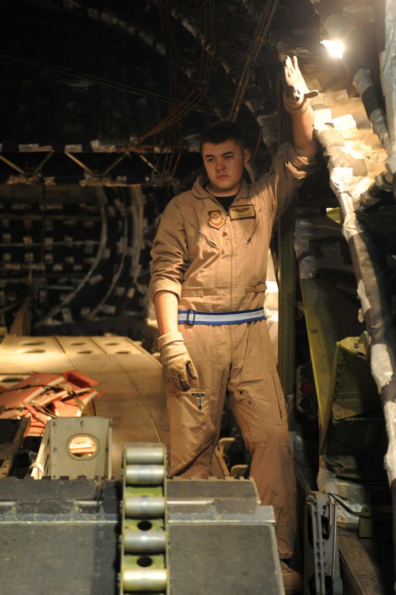 SOUTHWEST ASIA -Airman 1st Class Brad Benny, C-17 loadmaster, blocks a cargo compartment light with his hand to get a clear view of the cargo door operation on a C-17 aircraft Aug 14. Airman Benny is from Dover AFB, Del., and hails from Grain Valley, Mo. (U.S. Air Force photo/Tech. Sgt. Charles Larkin Sr)