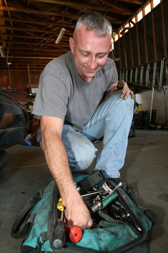 Sgt. Matthew A. Siegrist, a tool room chief with Marine Heavy Helicopter Squadron 466, gathers tools  to install a distributor cap, coil and ignition module for his 1968 Chevrolet Chevelle inside his hobby shop, Aug. 16. Siegrist has been working on cars for more than 20 years. (Official U.S. Marine Corps photo by Cpl. Christopher O'Quin)(Released)