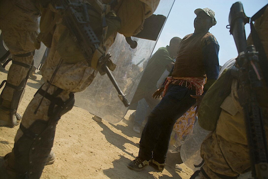 A role player harasses 11th Marine Expeditionary Unit Marines as they try to quell a restless crowd of hungry African villagers. Members of the 11th Marine Expeditionary Unit trained for several missions Aug. 16-17, including humanitarian assistance operations, noncombatant evacuation operations and mass casualty evacuations. The MEU is currently at sea until Aug. 21 conducting their certification exercise, the final piece of their training before deploying later this year. Most of the role players in the humanitarian assistance training were actual African refugees now living in the San Diego area.