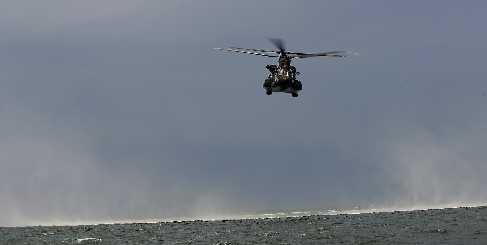 HURLBURT FIELD, FL -- A CH-47 Chinook flies over the Gulf of Mexico after hoisting U.S. Army Soldiers to safety Aug 5. The hoist and helo-cast training they conducted is part of a month-long joint operations and tactics course offered by the 1st Special Operations Support Squadron joint liaison flight. The CH-47 is from Task Force 160th Special Operations Aviation Regiment, Fort Bragg, N.C. (U.S. Air Force photo by Senior Airman Julianne Showalter) (RELEASED)