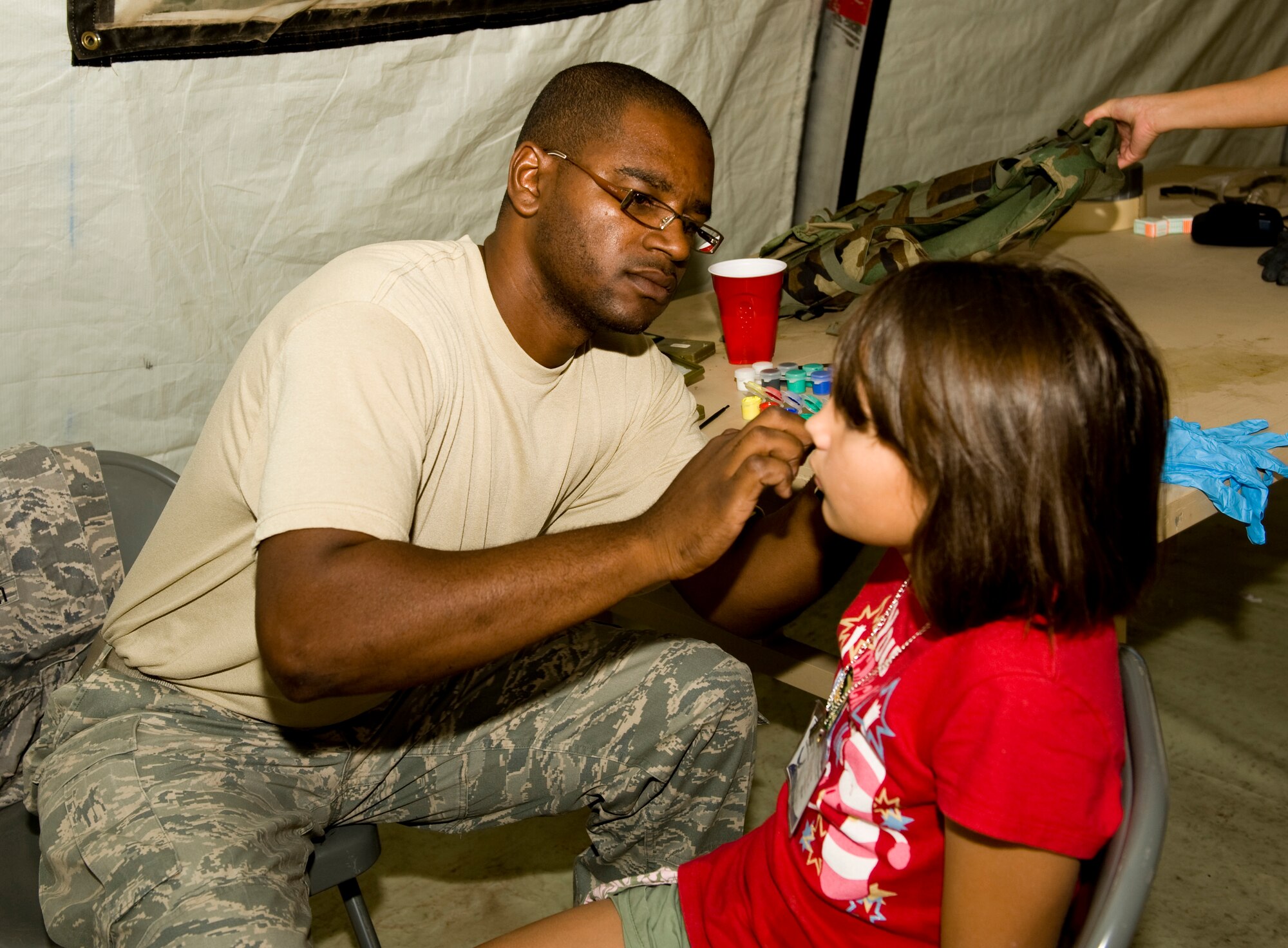 HOLLOMAN AIR FORCE BASE, N.M. -- Tech. Sgt. Vincent Hamilton, 49th Security Forces Squadron, applies face paint to children as part of Operation K.I.D. here Aug. 14. The event was attended by more than 100 children of military members and sponsored by the Airman and Family Readiness Center. (U.S. Air Force photo by Tech. Sgt. Alan Port)