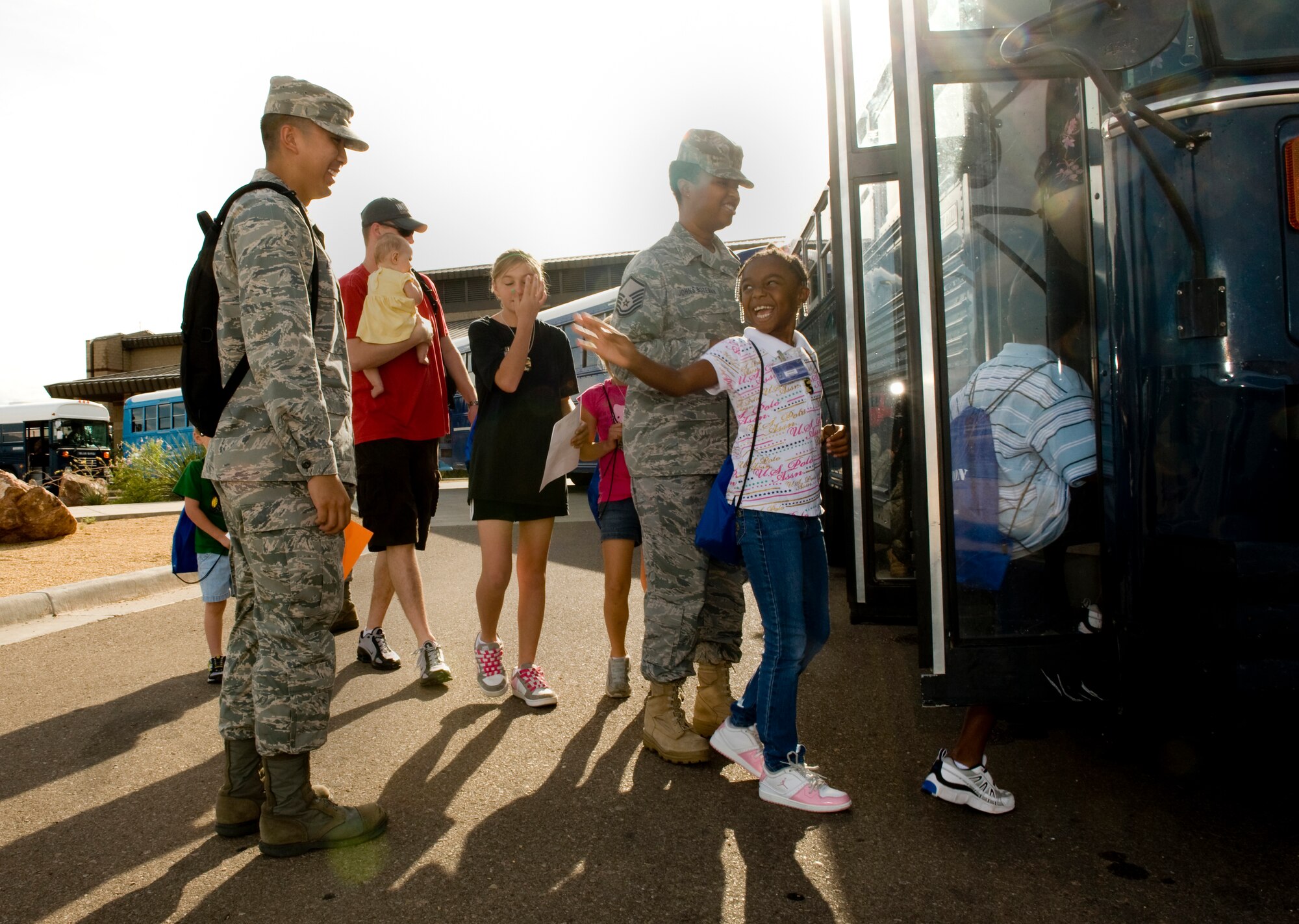 HOLLOMAN AIR FORCE BASE, N.M. -- Jai Bozeman waves to her chalk leader, 2nd Lt. Jonathan Abueg, 49th Communications Squadron, as she boards a bus to a mock deployment site during Operation K.I.D. The event took place Aug. 14 at Basic Expeditionary Airfield Resources (BEAR) Base here. (U.S. Air Force photo by Tech. Sgt. Alan Port)