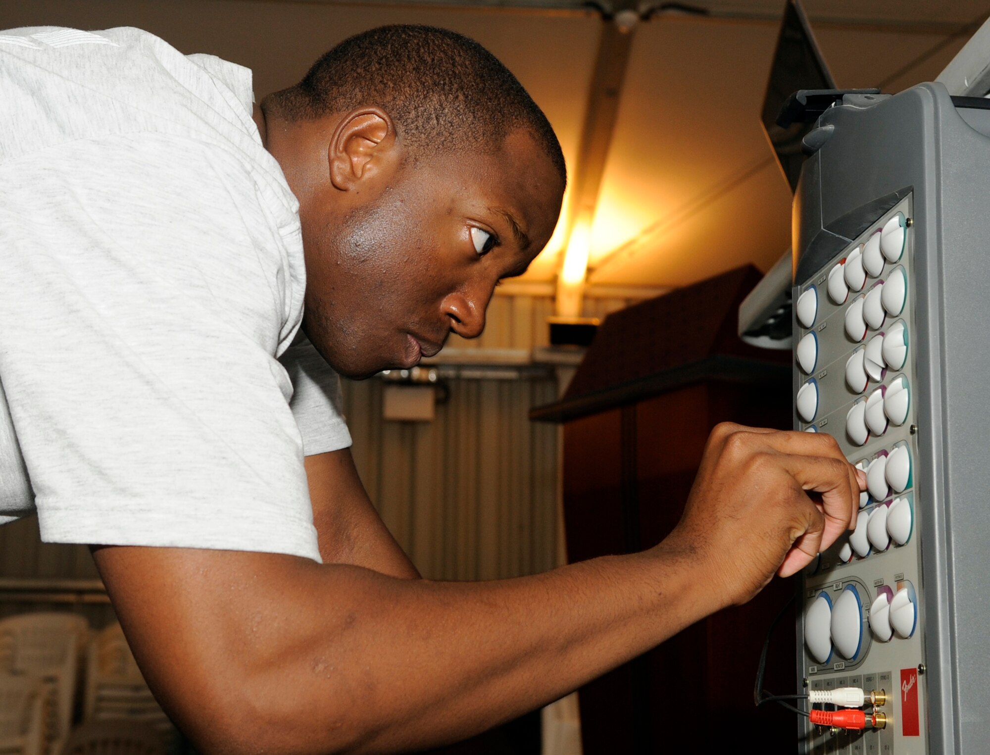 SOUTHWEST ASIA – Staff Sgt. Marcus Thompson, 380th Expeditionary Security Forces Squadron, adjusts the sound system while preparing for the block party Aug. 15. The block party was sponsored by the Base Advisory Council. (U.S. Air Force photo/Senior Airman Stephen Linch)