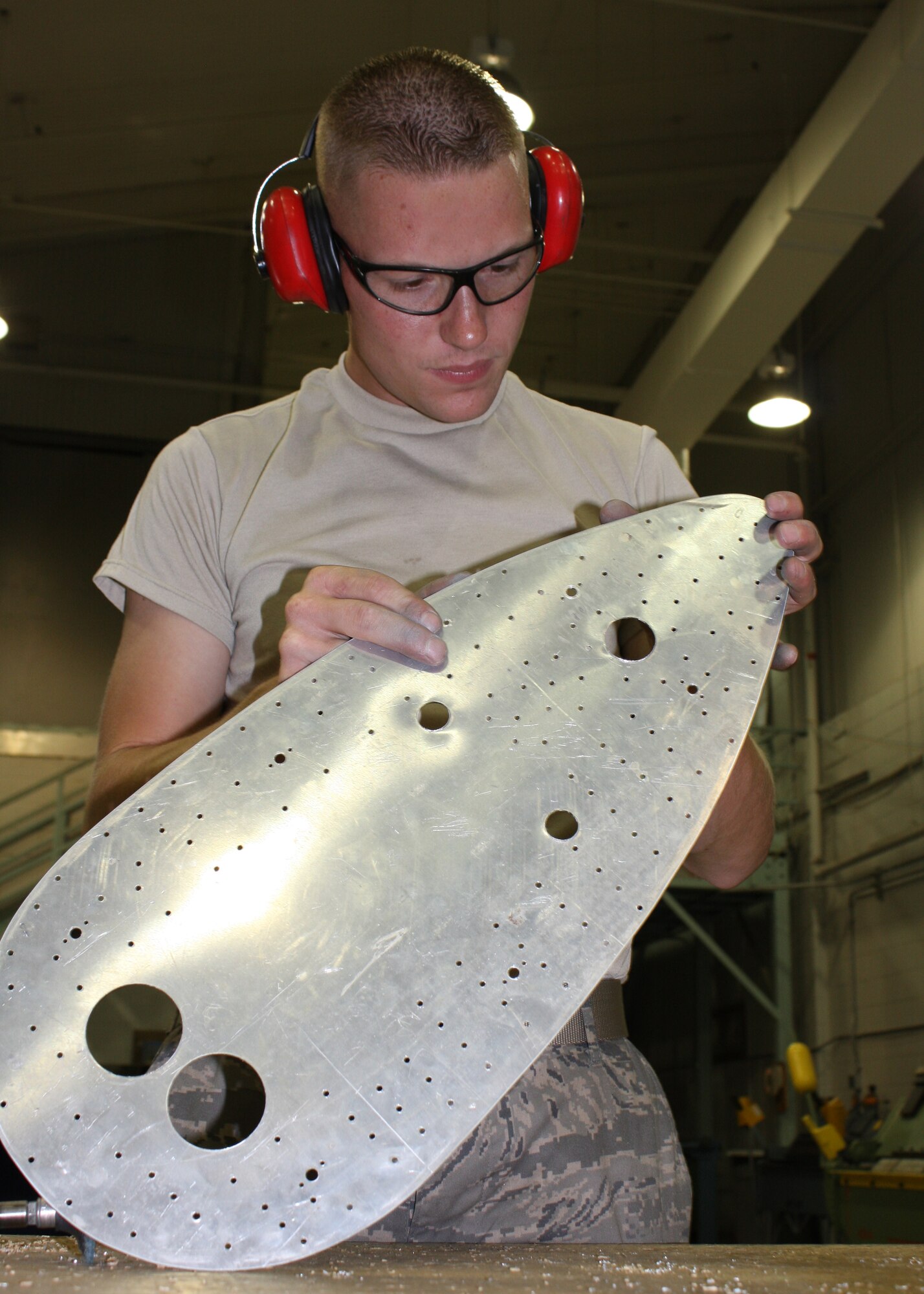 WRIGHT-PATTERSON AFB, Ohio - Staff Sgt. Dustin Rinehart, 445th Maintenance Squadron, inspects his work on a sheet metal patch for use on a C-5 Galaxy.  The patch will cover a hole left by a defective antenna dobler located on the top of the aircraft. (Air Force photo/Staff Sgt. Ken LaRock) 