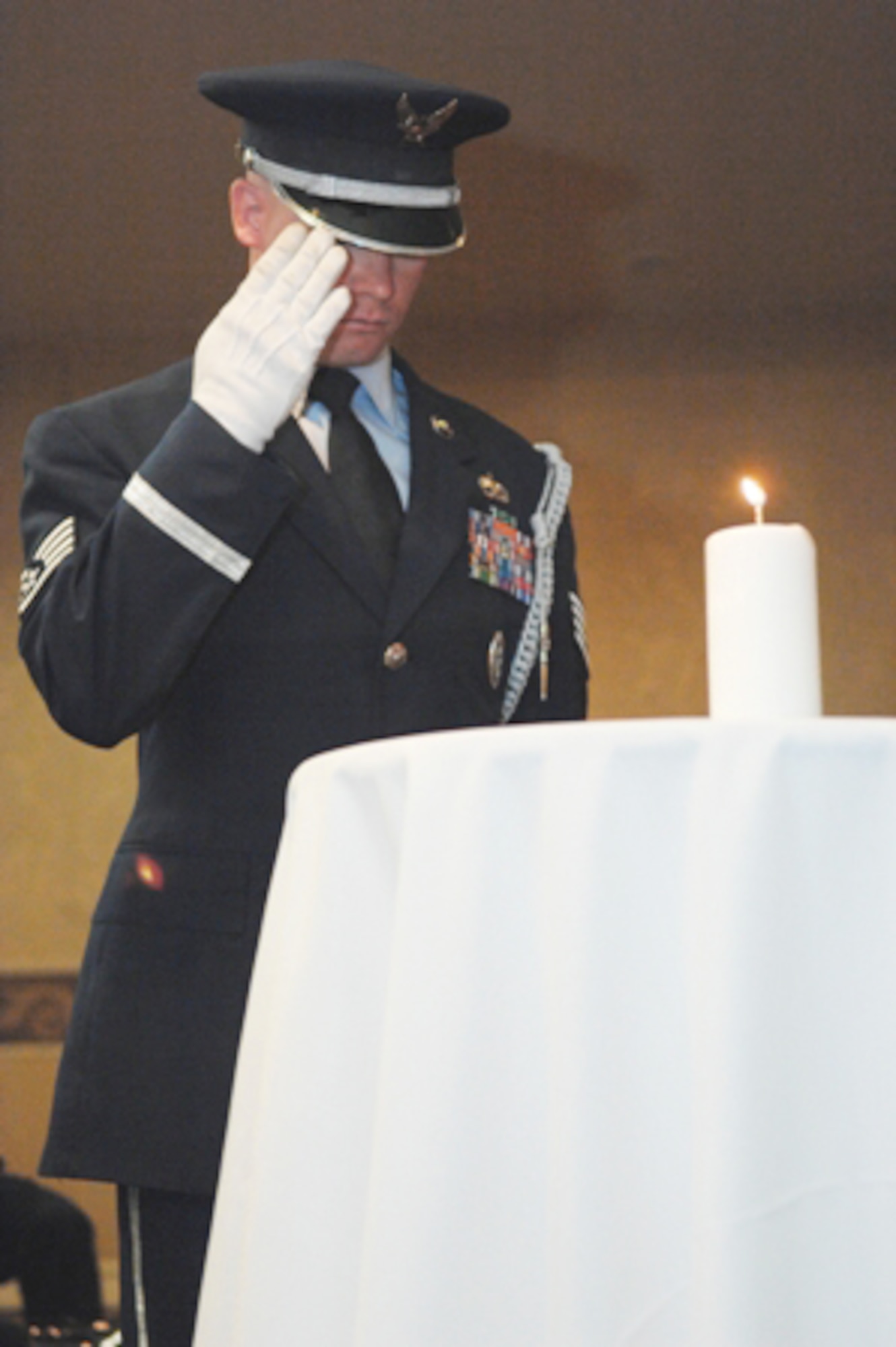 Staff Sgt. Chadd Wheeler salutes a candle during the Lonely Eagles Ceremony at the 38th Annual Tuskegee Airman, Inc. convention Aug. 7 in Las Vegas. TAI is a non-profit organization dedicated to honoring the accomplishments of the African-American air, ground and operations crew members in the Army Air Corps during World War II. Sergeant Wheeler is a 820th RED HORSE Squadron member from Nellis Air Force Base, Nev. (U.S. Air Force photo/Senior Airman Joseph Araiza) 
