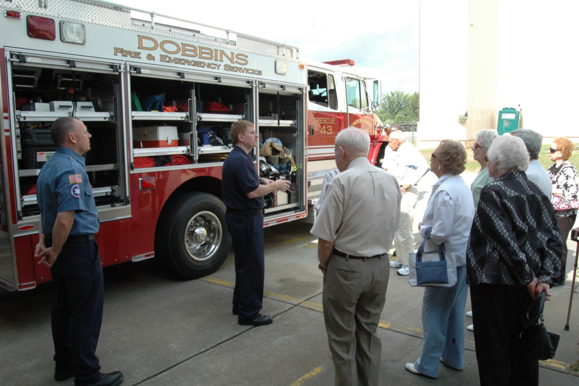Brian Dixon and Chris Dunlap of the Dobbins Fire Department demonstrate firefighting equipment to members of the Saint Anne's Terrace Retirement Community during a base tour Aug. 14. (U.S. Air Force photo/Senior Airman Shaun Shenk)
