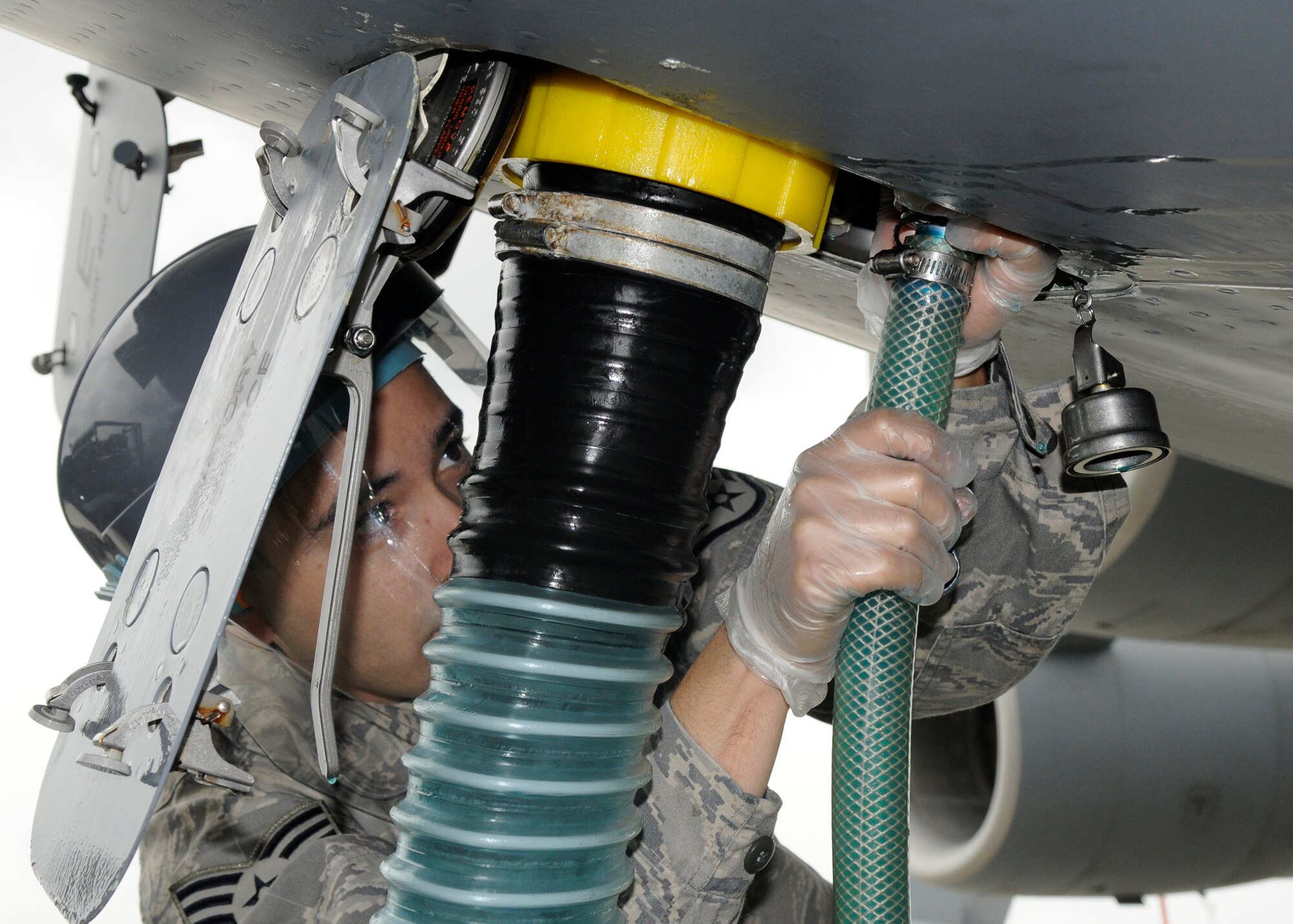 SPANGDAHLEM AIR BASE, Germany – Staff Sgt. Jesus Macias, 726th Aircraft Mobility Squadron air transportation journeyman, connects the cryotech, an aircraft lavatory fluid, hose during a routine latrine service on a C-17 Globemaster Aug 13. (U.S. Air Force photo by Airman 1st Class Staci Miller)