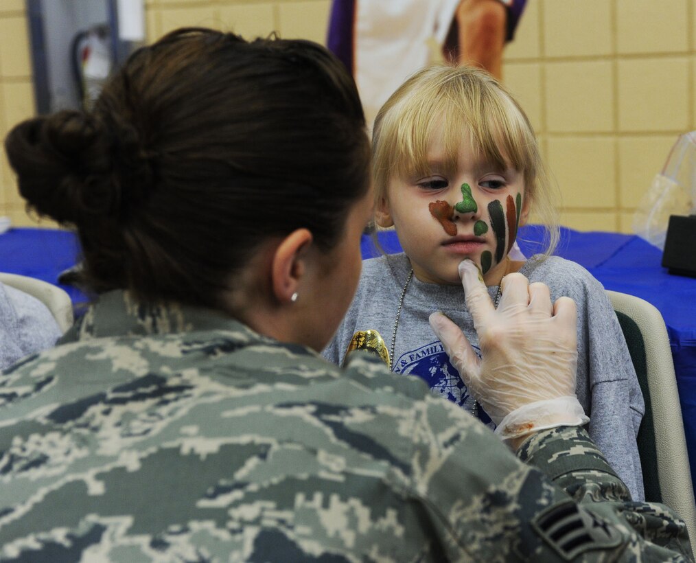 LANGLEY AIR FORCE BASE, Va. -- Senior Airman Stacia Rotroff,1st Logistic Readiness Squadron logistics planner, paints the face of Charity Newlon, daughter of Capt. Thomas Newlon, during Operatin Hero here Aug. 14. Operation Hero shows children some of the ways their parents prepare for deployment by letting them participate in various hands on activities. (U.S. Air Force photo/Senior Airman Scott Aldridge)