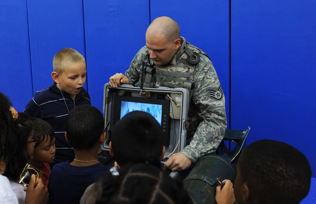 LANGLEY AIR FORCE BASE, Va. -- Staff Sgt. Andrew Goddard, 1st Civil Engineer Squadron explosive ordinance technician, demonstrates how to control the Talon, a robot that is used to help with the disposal of explosives, to children attending Operation Hero here Aug. 14. Operation Hero shows children some of the ways their parents prepare for deployment by letting them participate in various hands on activities. (U.S. Air Force photo/Senior Airman Scott Aldridge)