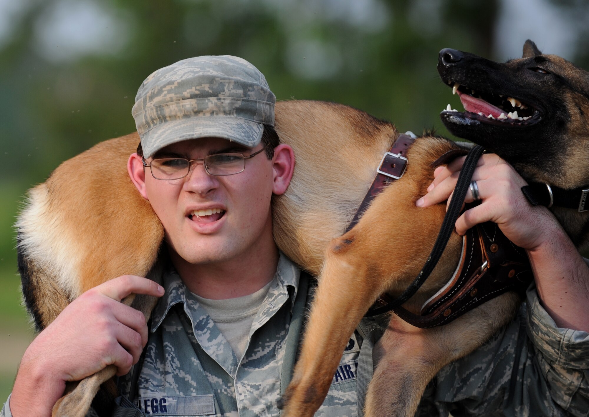 MOODY AIR FORCE BASE, Ga. -- Senior Airman Beaun Clegg, 822nd Security Forces Squadron military working dog handler, carries Rreyana during a training exercise here July 9. Airman Clegg is Rreyana’s first dog handler here at Moody. (U.S. Air Force photo by Senior Airman Gina Chiaverotti-Paige)