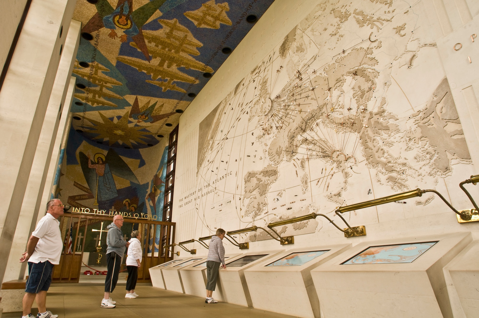 Visitors look around the monument and chapel at the Cambridge American Cemetery and Memorial. The monument includes two military maps, a mosaic ceiling memorial to the Airmen who died halting tyranny from griping the world, and military decorations. (U.S. Air Force photo by Staff Sgt. Nathan Gallahan)