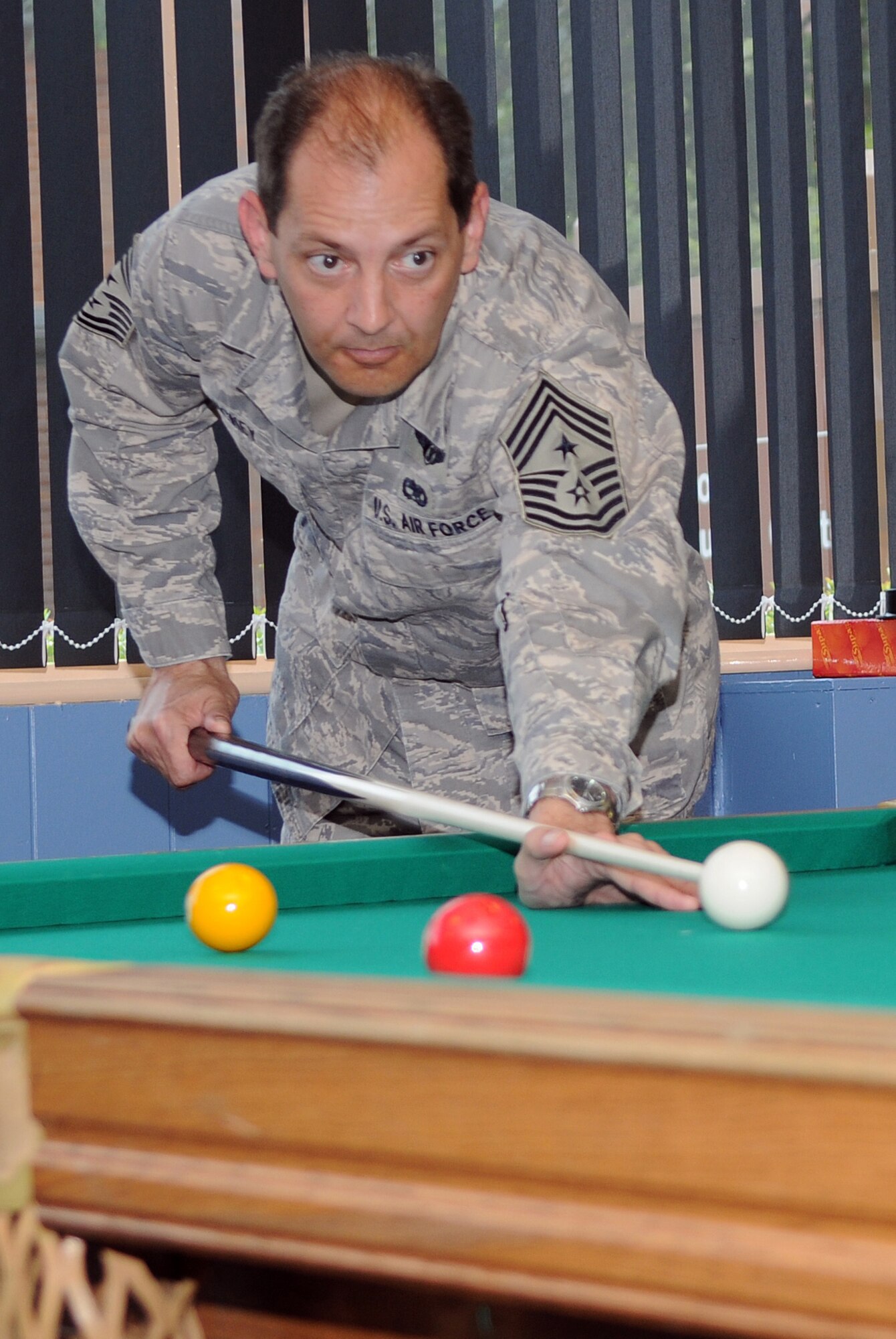 RAF MILDENHALL, England -- Chief Master Sgt. Antonio Hickey lines up a shot at the reopening of the Game Zone Aug. 5. The Game Zone, located at the Bob Hope Community Center, received $78,000 worth of upgrades from U.S. Air Forces in Europe quality of life improvement funds. The room is open for everyone 18 and older during normal community center operating hours and to teenagers aged 13 to 18 years from 4 to 6 p.m. Monday through Friday. (U.S. Air Force photo by Senior Airman Thomas Trower)