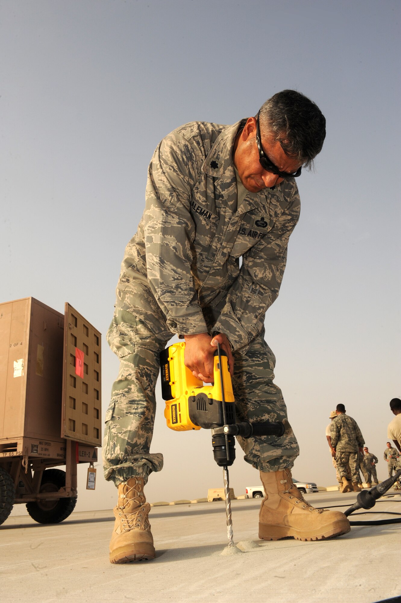 SOUTHWEST ASIA -Lt. Col. Jose Aleman, 380th Expeditionary Mission Support Group deputy commander, takes his turn drilling holes in the concrete to install runway lights Aug. 15. Colonel Aleman hails from Ciblo, Texas. (U.S. Air Force photo/Tech. Sgt. Charles Larkin Sr)