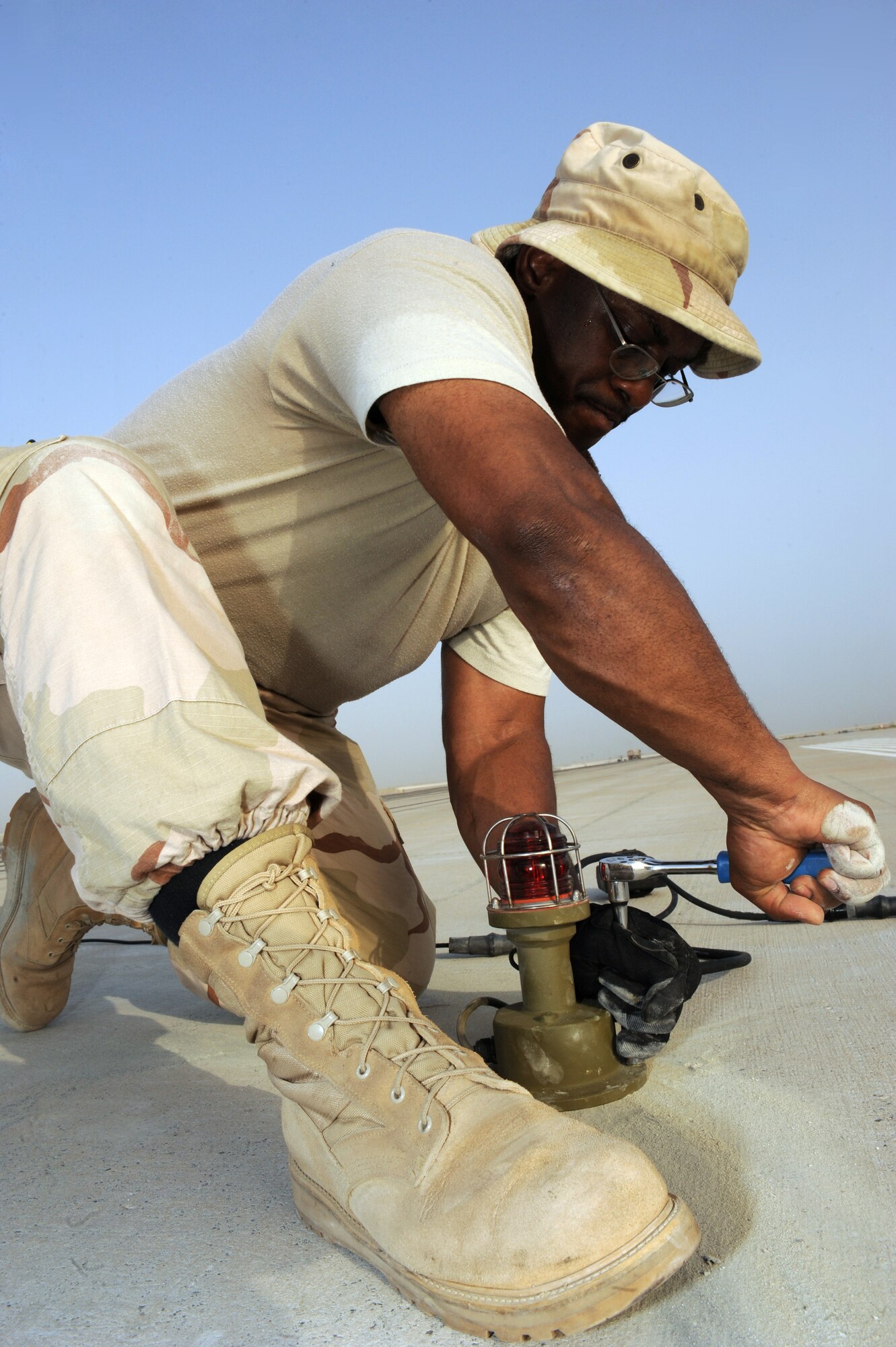 SOUTHWEST ASIA -Master. Sgt. Darryl Harris, 380th Civil Engineer Squadron, finishes tightening the bolts on a runway light Aug. 15. Sergeant Harris is deployed from Spangdahlem AB, Germany, and hails from Detroit, Mich. (U.S. Air Force photo/Tech. Sgt. Charles Larkin Sr)