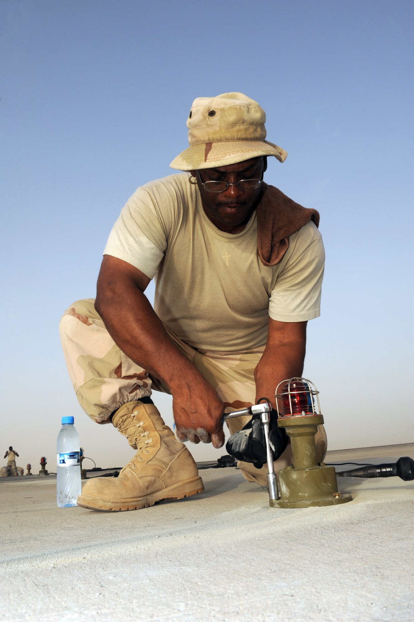 SOUTHWEST ASIA -Master Sgt. Darryl Harris, 380th Civil Engineer Squadron, tightens the bolts on a runway light Aug. 15. Sergeant Harris is deployed from Spangdahlem AB, Germany, and hails from Detroit, Mich. (U.S. Air Force photo/Tech. Sgt. Charles Larkin Sr)