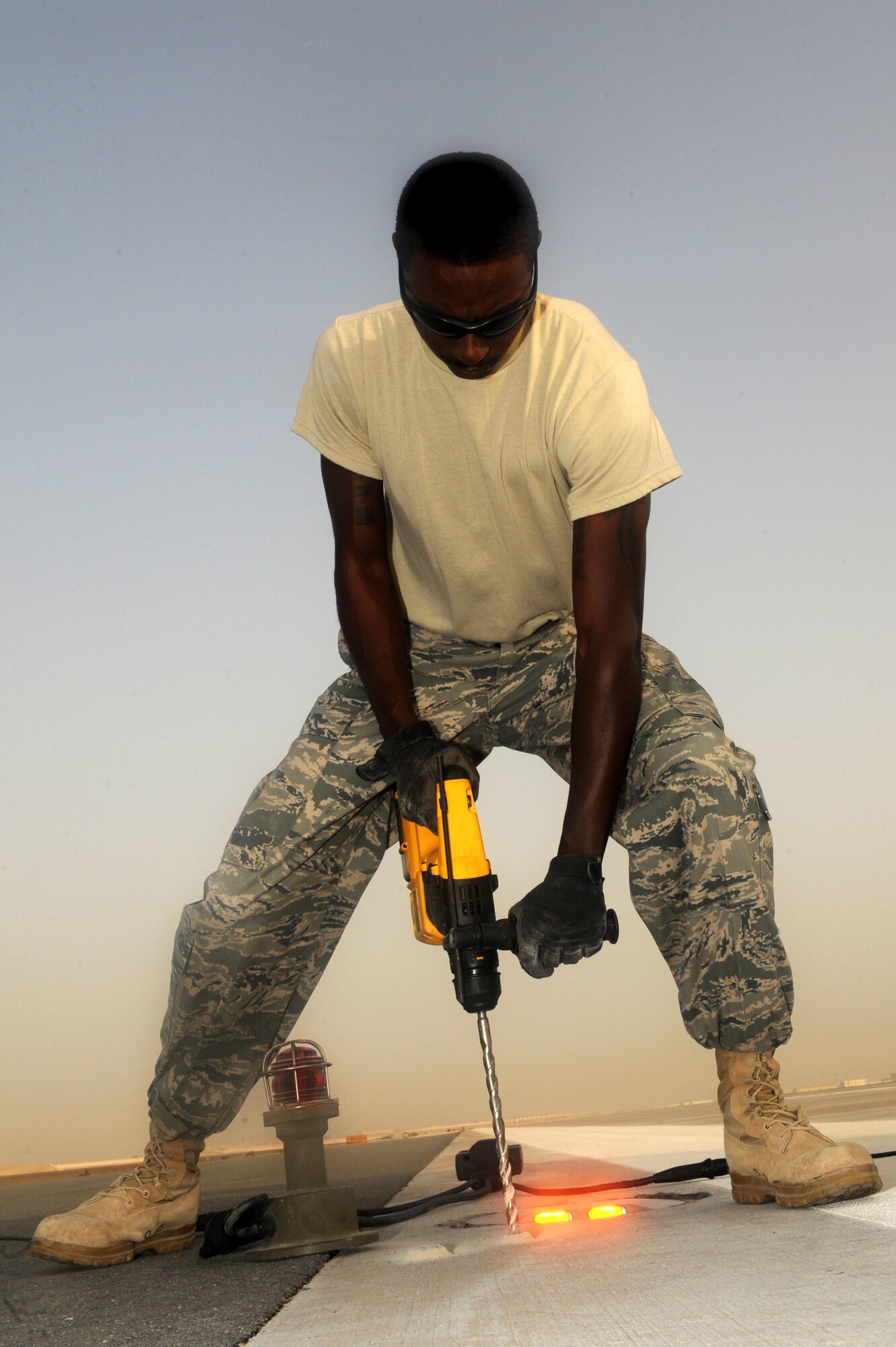 SOUTHWEST ASIA -Staff Sgt. Terrelle Jackson, 380th Expeditionary Civil Engineer Squadron, drills holes in the concrete to install a runway light Aug. 15. Sergeant Jackson is from Travis AFB, Calif., and hails from Sacramento, Calif. (U.S. Air Force photo/Tech. Sgt. Charles Larkin Sr)
