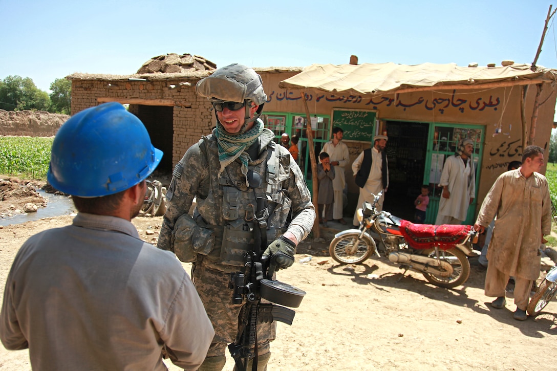 U.S. Army Sgt. Chris Miller talks to an Afghan construction worker during a reconnaissance mission in Kohistan in Kapisa province, Afghanistan, Aug. 9, 2009. Miller is an Inactive Ready Reserve infantryman assigned to the Kapisa-Parwan Provincial Reconstruction as part of their personal security detachment.