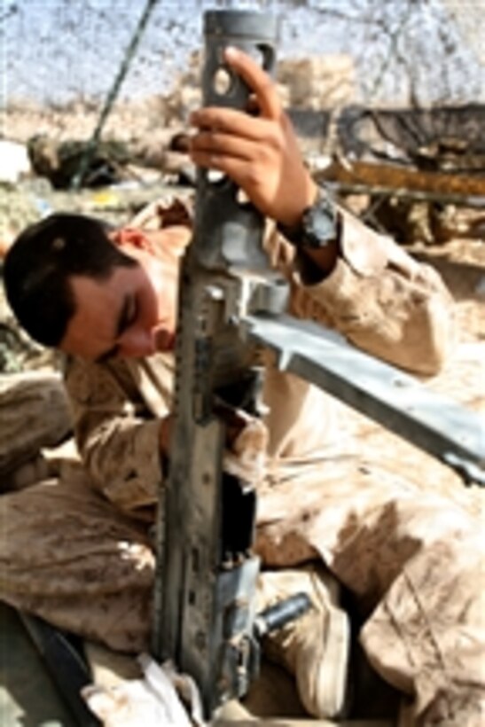 U.S. Marine Corps Lance Cpl. Eladio Avelino cleans a .50-caliber machine gun at Forward Operating Base Geronimo in the Nawa district of Afghanistan's Helmand province on Aug. 12, 2009.  Avelino is a motor transport operator deployed with the 1st Battalion, 5th Marine Regiment.  The Marines are conducting security patrols in the area to speak with residents to identify their issues and concerns.  The 1st Battalion, 5th Marine Regiment is deployed with Regimental Combat Team 3, which conducts counter insurgency operations in partnership with Afghan National Security Forces in southern Afghanistan.  