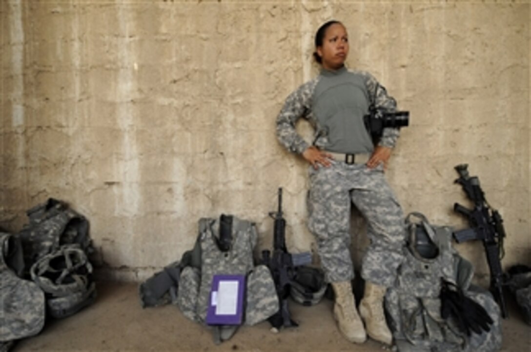 U.S. Air Force Senior Airman Kamaile Chan, assigned to Joint Combat Camera-Iraq, takes a break after completing a photo shoot at an Iraqi police vehicle maintenance compound in Wadi Hajar, Mosul, Iraq, on Aug. 10, 2009.  