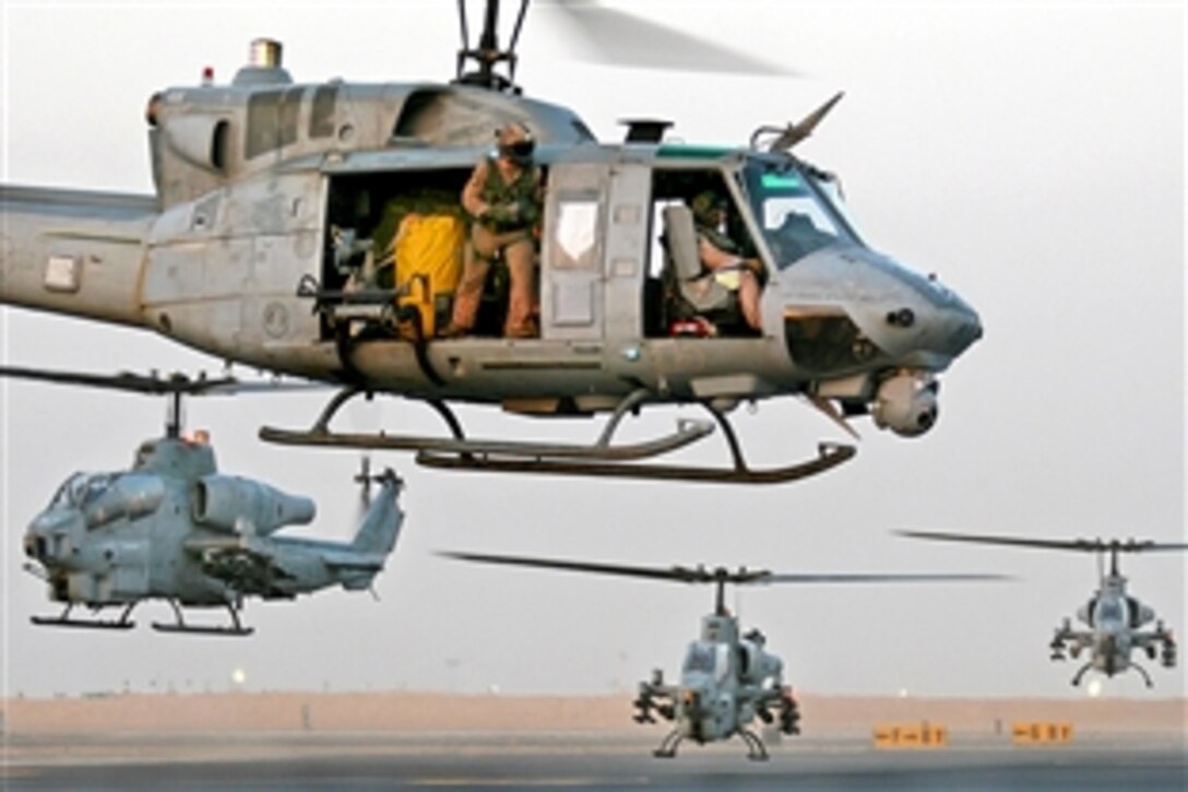 A UH-1N Huey helicopter and three AH-1W Super Cobras hover over Udairi Army Airfield, Kuwait, Aug. 10, 2009. Marines from the aviation combat element for the 22nd Marine Expeditionary Unit participated in sustainment training on Camp Buehring, Kuwait. The aircraft are assigned to Marine Medium Tiltrotor Squadron 263, 22nd Marine Expeditionary Unit. 