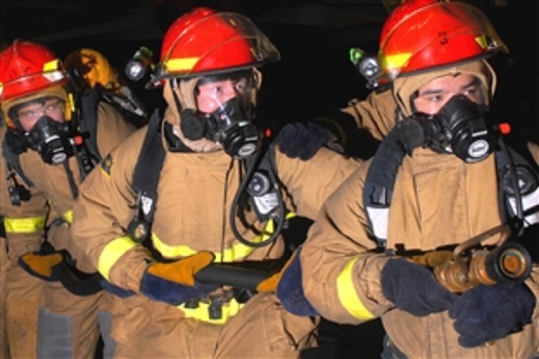 U.S. Navy personnel fight a simulated fuel fire in the hangar bay aboard the aircraft carrier USS Nimitz during a general quarters drill in the Pacific Ocean, Aug. 13, 2009. Nimitz and embarked Carrier Air Wing 11 are on a deployment to the western Pacific Ocean.