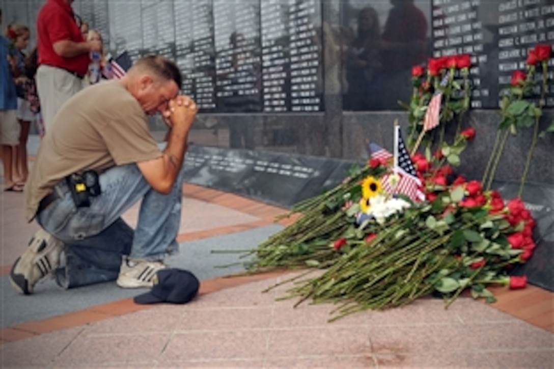 A mourner pays final respects to U.S. Navy Capt. Michael Scott Speicher at the Jacksonville Veterans Memorial Wall in Jacksonville, Fla., Aug. 14, 2009. Speicher was killed when his F/A-18 Hornet aircraft was shot down over the Anbar province of Iraq Jan. 17, 1991, on the first day of offensive operations during Operation  Desert Storm. 